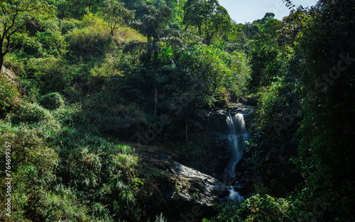 View of Iruppu waterfalls in Coorg or Madikeri, Karnataka, India. Western ghats falls in long exposure. Green trees and forest. Milky waterfalls. Karnataka tourism site.  photo