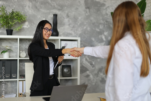 In a corporate setting, business partners engage in a handshake, symbolizing cooperation and success.