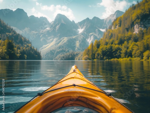 The front of a kayak on a lake with forested mountains in the background © Anna Baranova