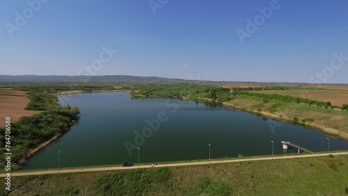 Idyllic aerial footage of clean lake under clear blue sky in countryside photo