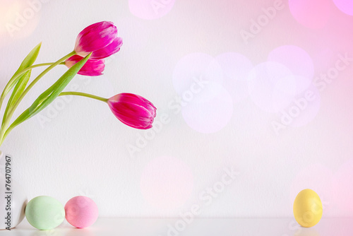 Spring pink tulip flowers with Easter eggs on pink background photo