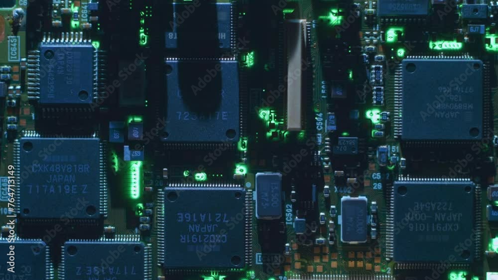 A printed circuit board with many microchips and other radio components that cast shadows that follow the light source. Closeup. Macro A printed circuit board with many microchips and other radio components that cast shadows that follow the light source. Closeup. Macro