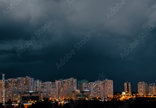 Dramatic stormy dark cloudy sky over row of typical residential district.