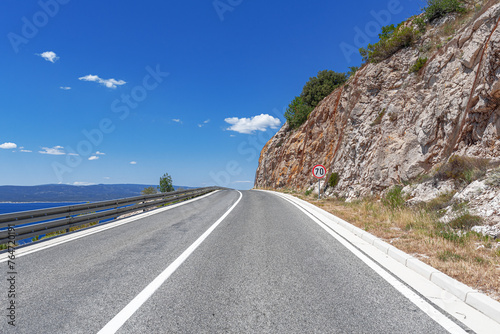 Mountain highway with blue sky and sea on a background