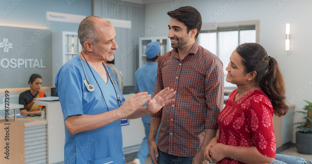 Fototapeta premium Indian Couple Visiting a Local City Hospital for a Health Check Up: Young Husband and Wife Talking to Their Doctor, Discussing Fertility Treatment Options