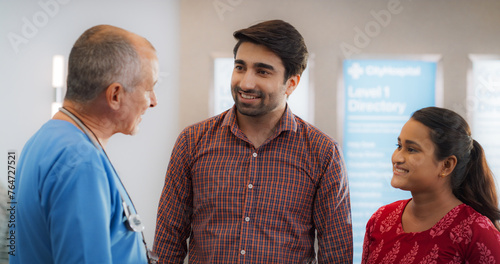 Indian Couple Visiting a Local City Hospital for a Health Check Up: Young Husband and Wife Talking to Their Doctor, Discussing Fertility Treatment Options photo