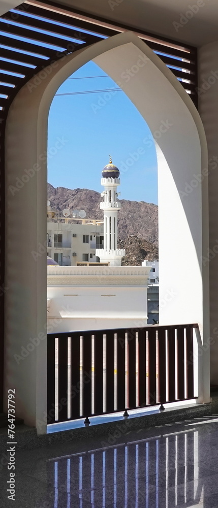 Obraz premium Elegant Archway Framing A White Mosque Minaret Against Blue Sky