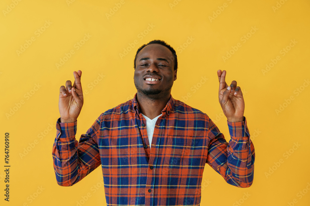 Making hand gestures. Black man is in the studio against yellow background Making hand gestures. Black man is in the studio against yellow background
