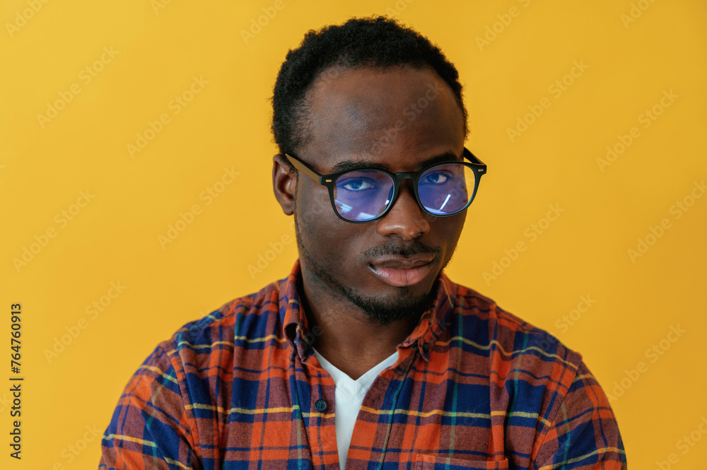 Standing and posing. Black man is in the studio against yellow background Standing and posing. Black man is in the studio against yellow background