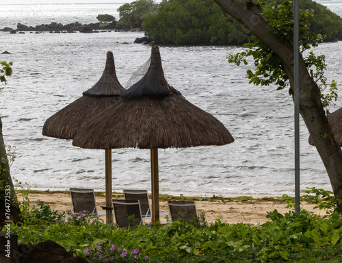 Sun umbrella and beach beds on tropical coastline, in Mauritius photo