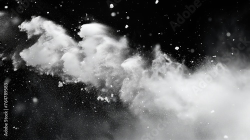 Black and white image of a dynamic powder burst creating a cloudy texture against a dark background.