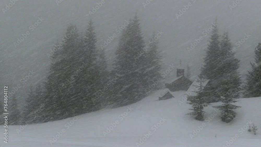 strong snow blizzard in winter, Carpathians, Ukraine Orthodox church on top of the mountain. coniferous forests, snow flies like a storm in front of the viewer, covering the mountain valley