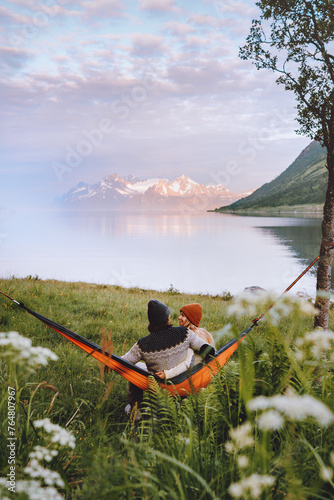 Couple in love chilling in hammock man and woman traveling together summer vacations friends on camping trip outdoor in Norway family lifestyle boyfriend and girlfriend hugging romantic feelings