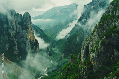 Cinematic shot of the view from above  looking down at an epic mountain range with clouds rolling over and mist hanging in between mountains  green grass on cliffs