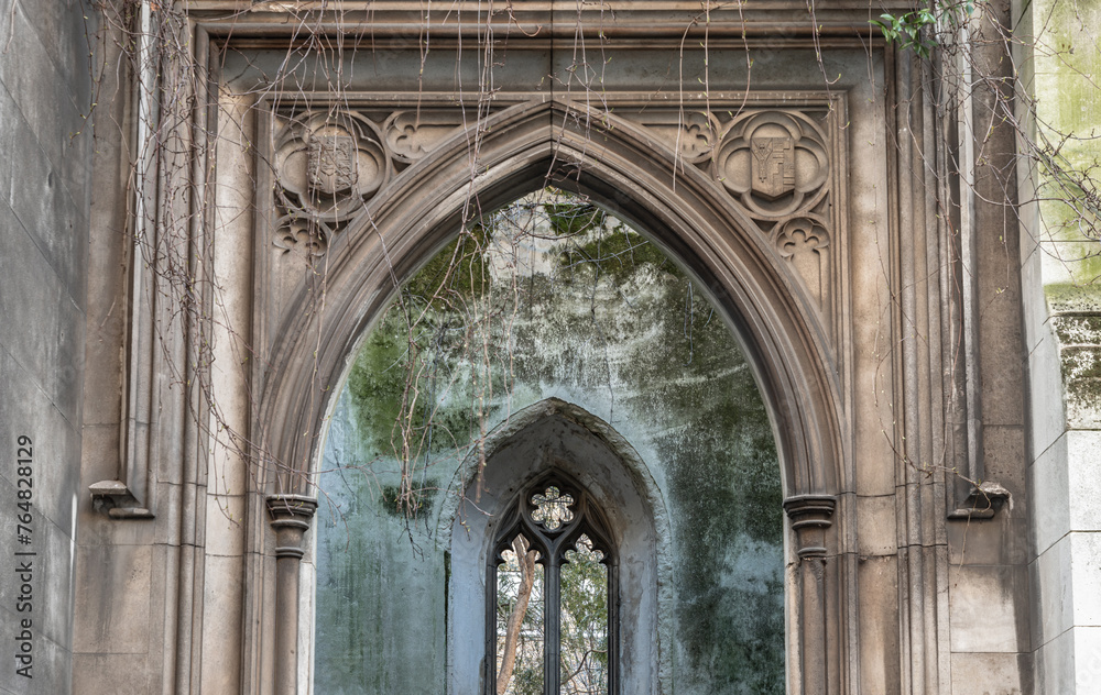 Perspective view of The stone arched entrance and Stone window frame inside of St Dunstan in the East Church Garden. The historic church was bombed and destroyed in the Second World War and is now.