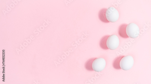 Group of white eggs. Pink background. Minimal concep of nutrition, protein or Easter holiday.