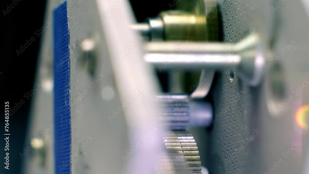 Speed reducer motor with many rotating metal gears shining in the light. Closeup. Macro Speed reducer motor with many rotating metal gears shining in the light. Closeup. Macro