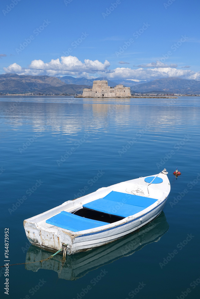 Beautiful small castle of Bourtzi built at sea a popular attraction in city of Nafplio former capital of Greece as seen at spring morning with nice white clouds and deep blue sky, Argolida, Greece