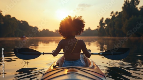 afro woman paddling in a kayak in the lake --ar 16:9 Job ID: b19ec4b2-2689-4fef-b94e-9a0d82a1a4c3 © urdialex