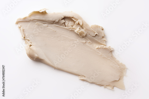 Close-up view of a textured beige cosmetic clay smear