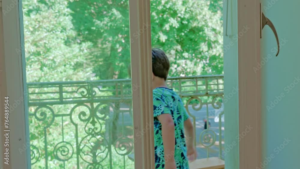 Little Boy Opens Apartment Balcony Door To Observe Neighborhood At Sunshine Day Little Boy Opens Apartment Balcony Door To Observe Neighborhood At Sunshine Day