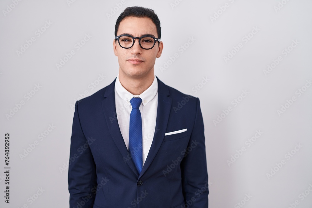Young hispanic man wearing suit and tie relaxed with serious expression on face. simple and natural looking at the camera. Young hispanic man wearing suit and tie relaxed with serious expression on face. simple and natural looking at the camera.