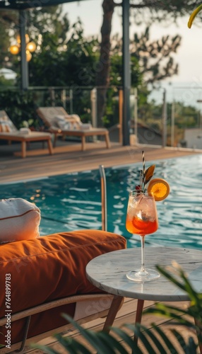 A glass of wine is on a table next to a pool