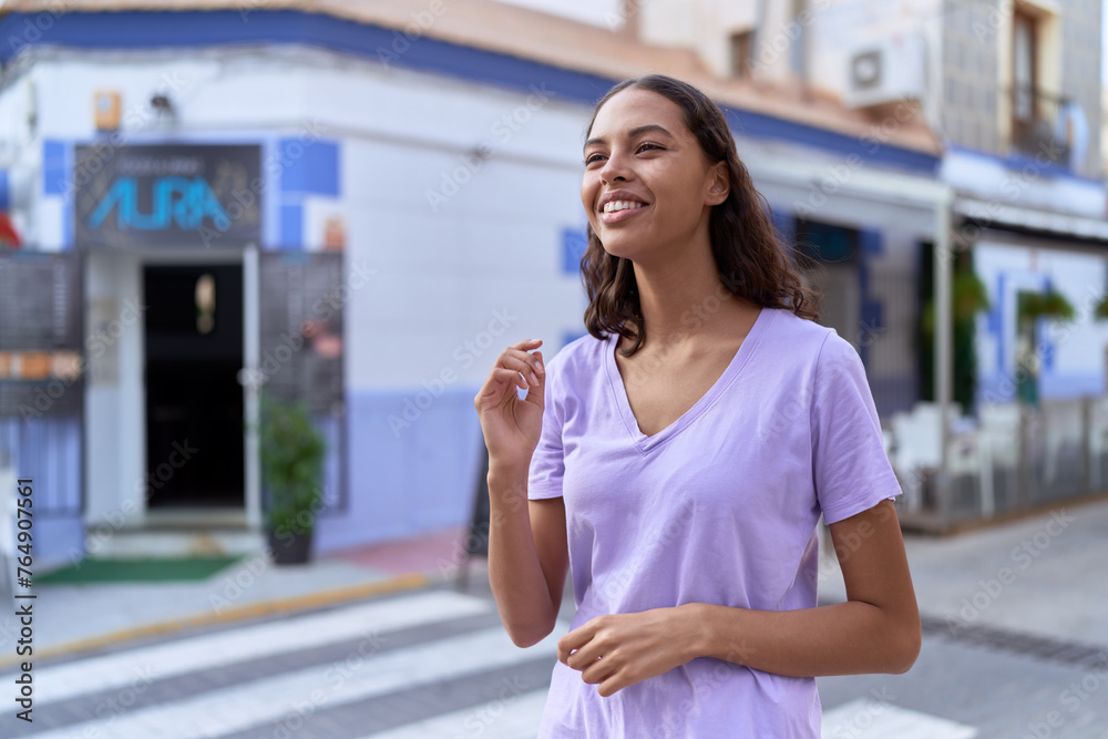 Young african american woman smiling confident looking to the side at coffee shop terrace Young african american woman smiling confident looking to the side at coffee shop terrace