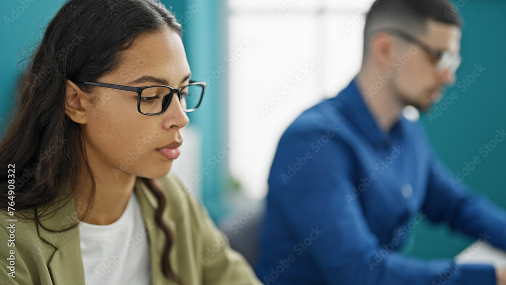 Two professional workers, man and woman, laser-focused on success, engrossed in their computer work, bonding as partners in the office interior Two professional workers, man and woman, laser-focused on success, engrossed in their computer work, bonding as partners in the office interior