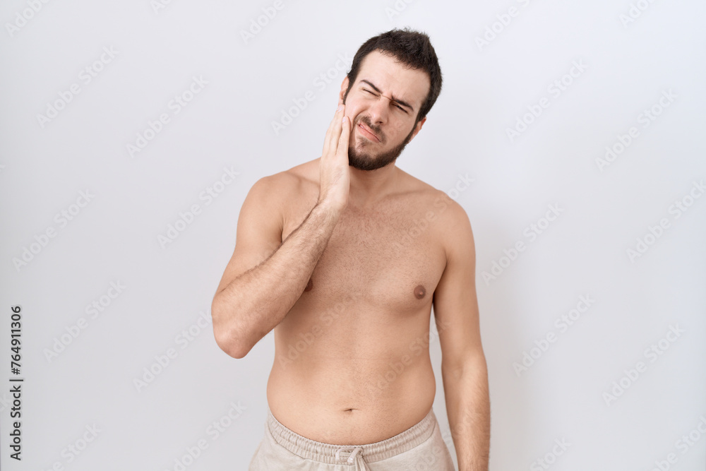 Young hispanic man standing shirtless over white background touching mouth with hand with painful expression because of toothache or dental illness on teeth. dentist