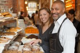joyous cafe duo, diverse and united, display bakery delights, warm rapport evident in shared smiles, amidst the morning rush.Delighted team offers fresh pastries, radiating friendly collaboration