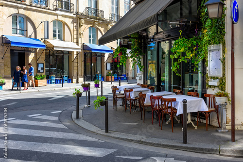 Cozy street with tables of cafe  in Paris, France. Cityscape of Paris. Architecture and landmarks of Paris
