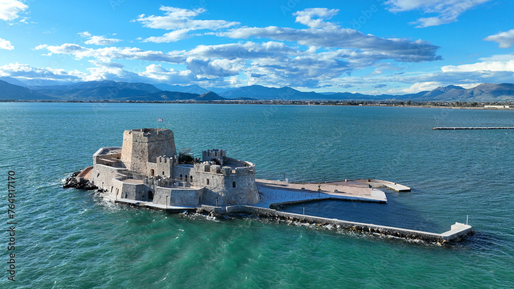 Aerial drone photo of castle of Bourtzi built at sea a popular attraction in city of Nafplio former capital of Greece as seen in the morning with nice white clouds and deep blue sky, Argolida, Greece Aerial drone photo of castle of Bourtzi built at sea a popular attraction in city of Nafplio former capital of Greece as seen in the morning with nice white clouds and deep blue sky, Argolida, Greece