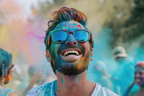 Man celebrates Holi festival with colorful paint and friends.