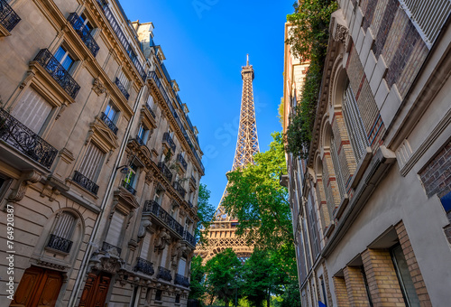 View of Eiffel Tower and cozy street in Paris, France. Eiffel Tower is one of the most iconic landmarks of Paris