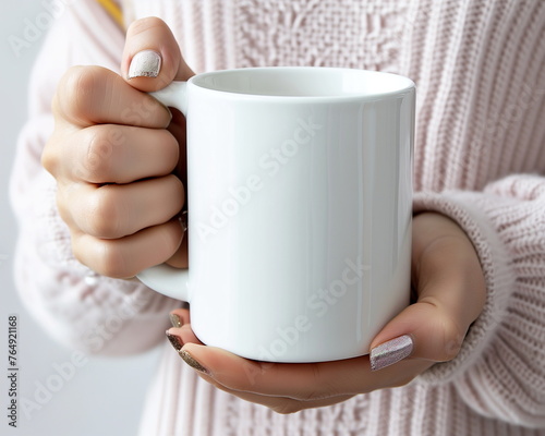 Woman's hands holding a blank white mug for mockup.