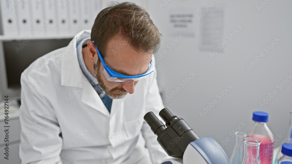 A middle-aged hispanic man with a beard working attentively in a laboratory setting. A middle-aged hispanic man with a beard working attentively in a laboratory setting.