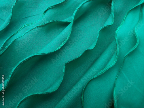 a collection of thin green cotton cloth with wavy edge stitching. background of pile of thin sewing utem fabric. fabric with soft textured folds. handycrafts photo