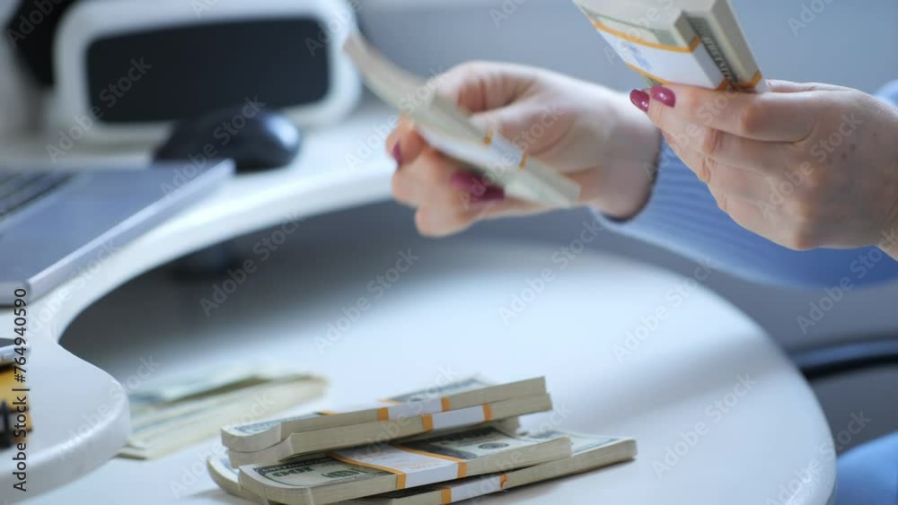 close-up of female hands counting a stack of hundred-dollar US banknotes. a businesswoman is counting cash. the concept of investment, money exchange, bribes or corruption. 4K close-up of female hands counting a stack of hundred-dollar US banknotes. a businesswoman is counting cash. the concept of investment, money exchange, bribes or corruption. 4K
