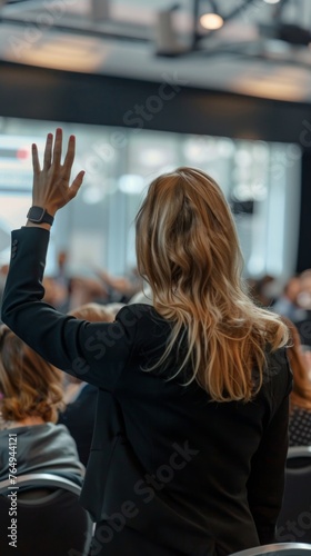 young woman raising her hand during a business meeting. 