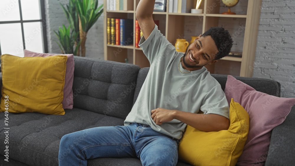 Cheerful man stretching on a comfortable couch in a cozy living room