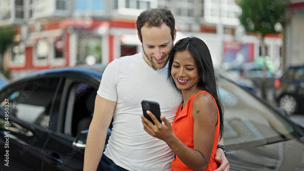 Beautiful couple using smartphone standing by car at street Beautiful couple using smartphone standing by car at street
