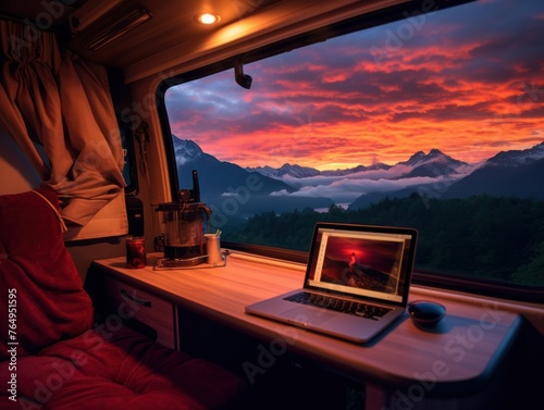 lifestyle, through the bed and from behind at a narrow mobile home, laptop on the table from the window, incredible view the landscape bright blue sky, orange and red sunset. travel, vacation. work