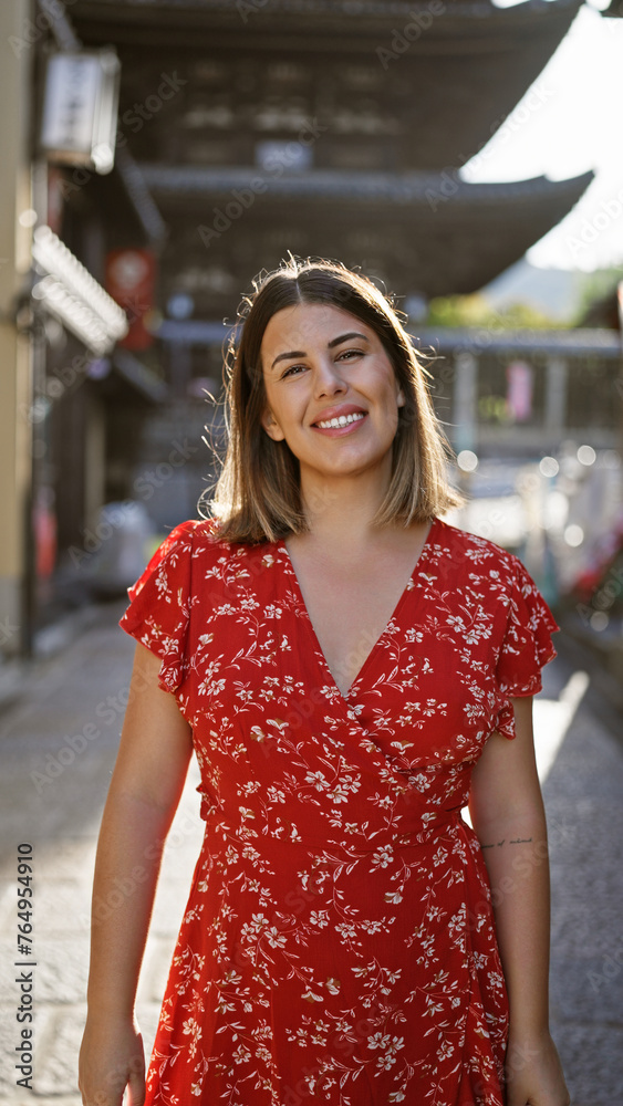 Beautiful hispanic woman smiling joyfully, confidently posing, standing on the old traditional streets of gion, kyoto, her sunny, carefree nature shining through for a fun-filled japan adventure.