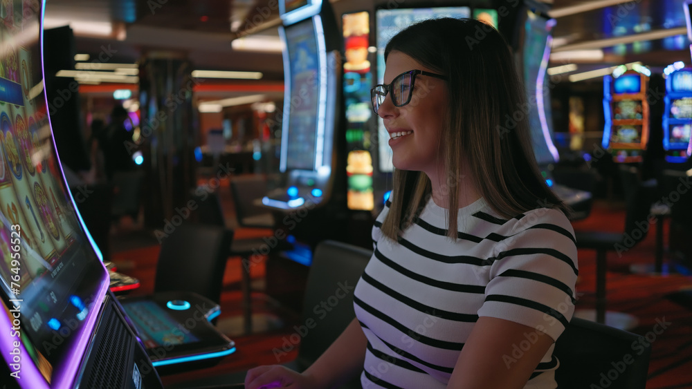 Fototapeta premium Smiling woman playing slot machine at a vibrant casino, epitomizing leisure, excitement, and jackpot potential.