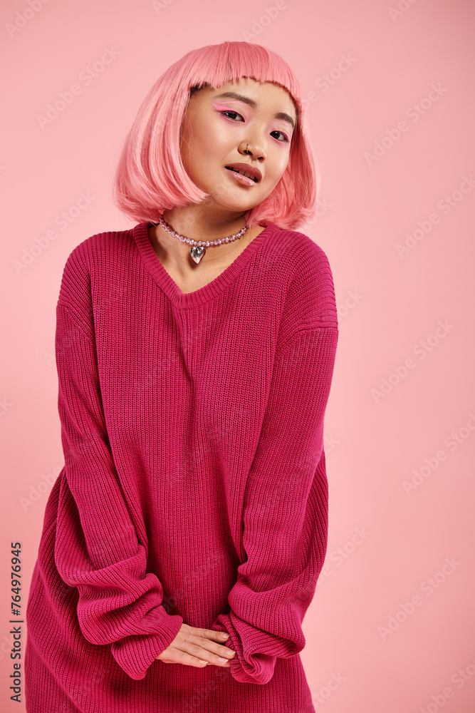 playful asian woman with pearl necklace in vibrant sweater outfit cute posing on pink background playful asian woman with pearl necklace in vibrant sweater outfit cute posing on pink background