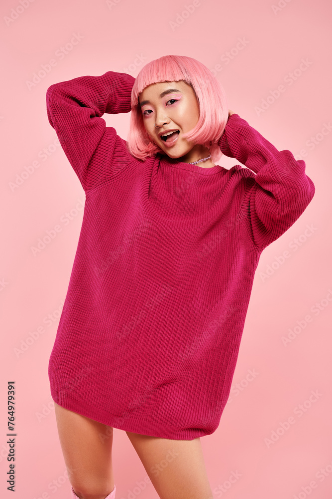 cute asian young woman with pink hair and makeup in big sweater against vibrant background