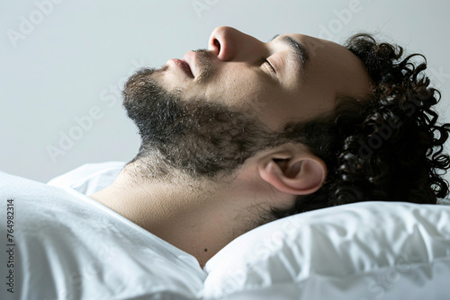 Side view of a curly-haired man sleeping peacefully