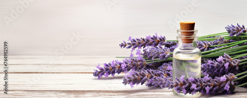 fresh lavender with Bottles of essential oil on a light wooden background, banner with copy space for text