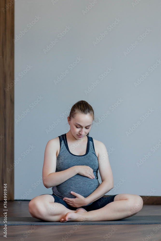 Happy beautiful pregnant woman before exercising at home